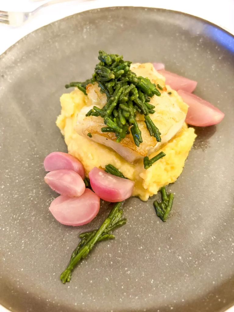 Gebratener Fisch auf Polenta mit Wildkräutern und Radieschen
